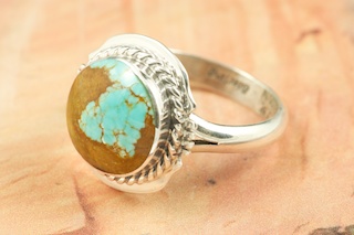 Genuine Number 8 Turquoise set in Sterling Silver Ring. The Number 8 mine is located in Eureka County Nevada. Since 1976 there has been no Number 8 Turquoise mined. There is however, an existing stock pile that Mr. Dowell Ward, the last owner of the Number 8 mine, had stocked away for later sorting. The Turquoise is a collector's item--because once the reserve is gone there will be no more material released onto the market. The Gold Mining Company owns the claim to the Number 8 mine and it has been swallowed up by the gold mining operations. This is some of the last Number 8 Turquoise to be had and will be a great addition to your collection. Created by Navajo Artist Arkie Nelson. Signed by the artist.